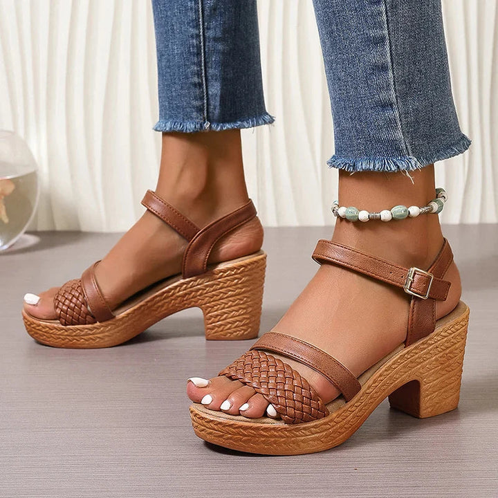 Woman wearing summer woven sandals on feet against a clean background.
