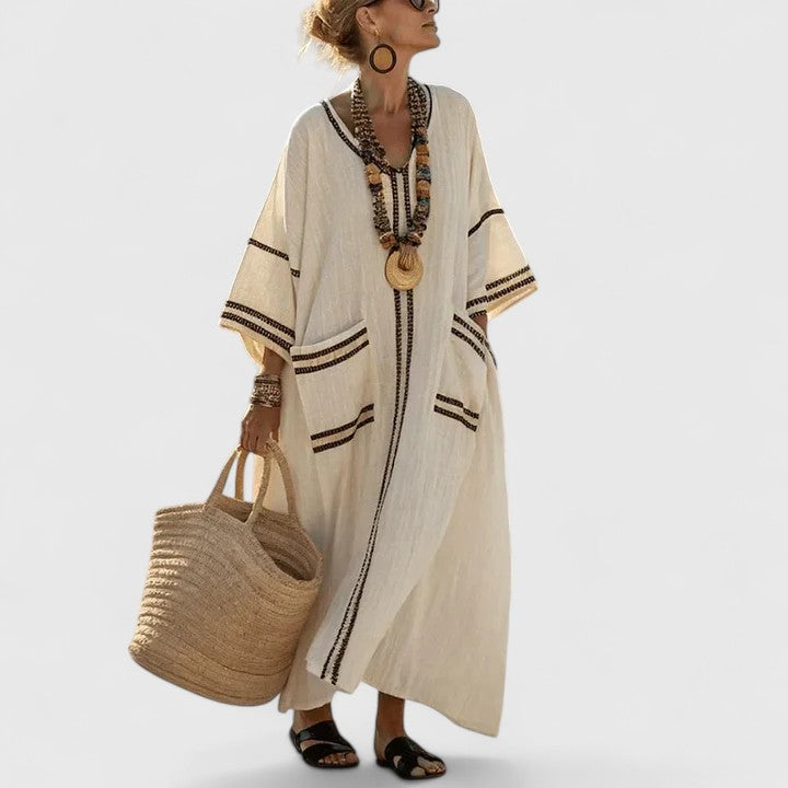 Flowing striped long dress shown on a plain background with teal trim and relaxed summer styling.