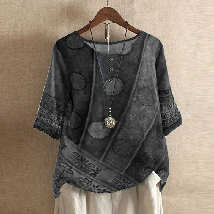 Classic feminine blouse shown on a plain background with soft fabric and graceful button accents