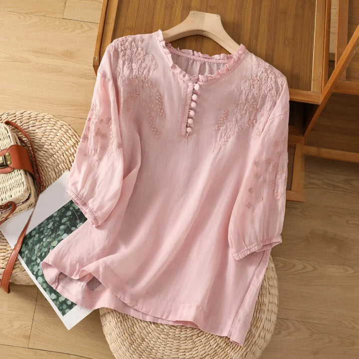 Timeless button-front blouse with graceful sleeves and stitched details.