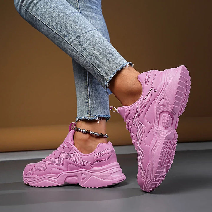 Female model wearing breathable walking sneakers against a plain background.