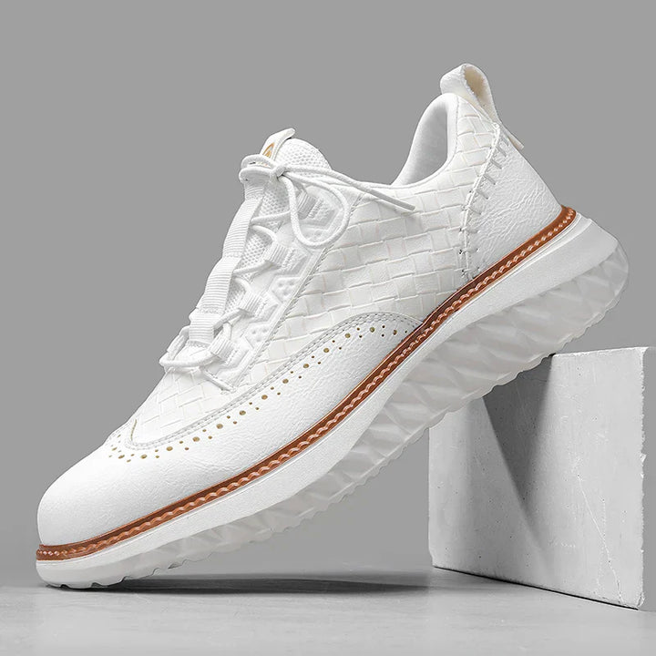 Casual lace-up sneakers shown on feet with a clean plain backdrop.