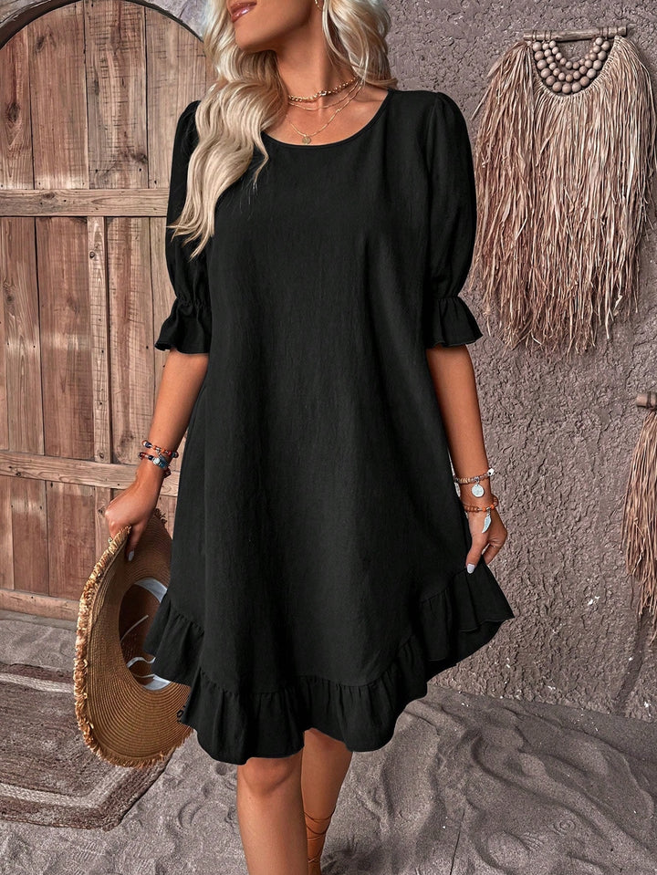  Woman wearing a breezy warm-weather dress on a plain background.
