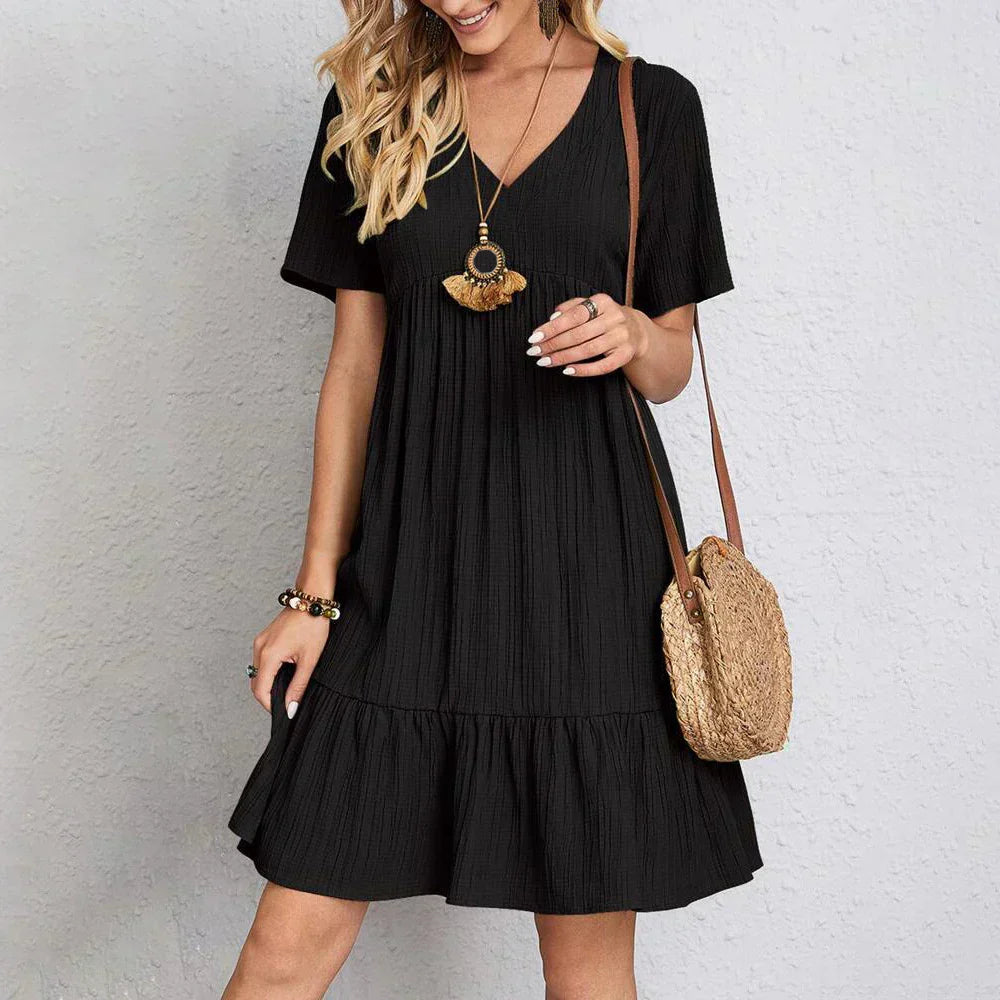Model wearing a warm-weather ruffle mini dress on a clean background.