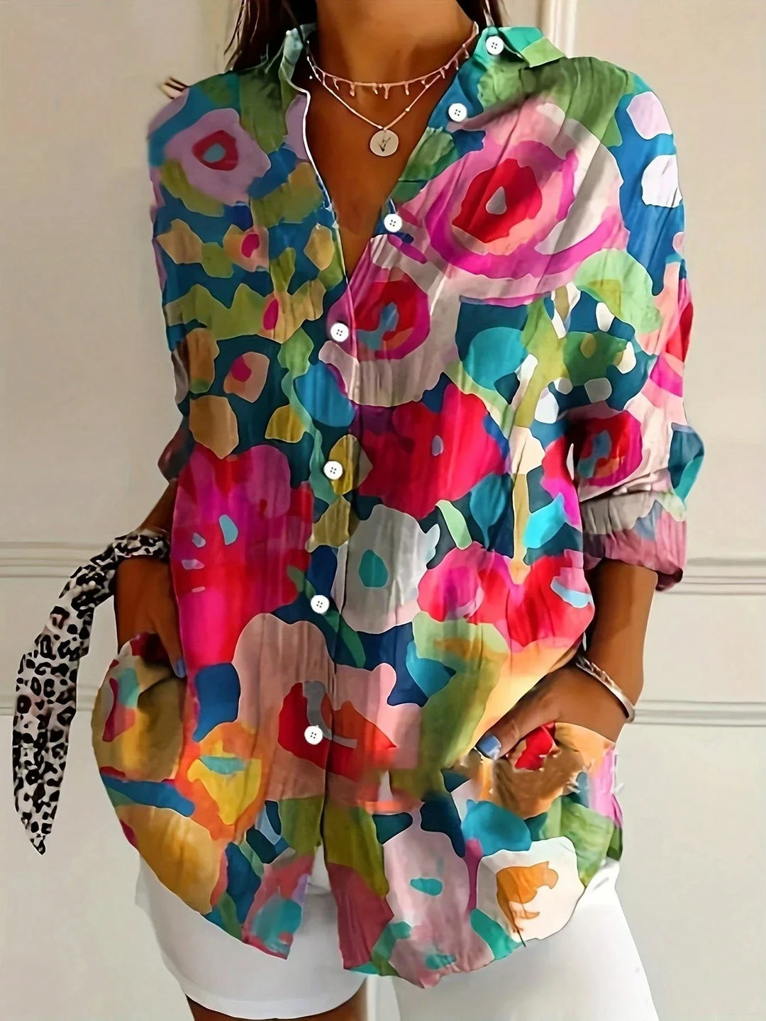 Bright casual blouse with airy fit shown w/ model against a plain background.