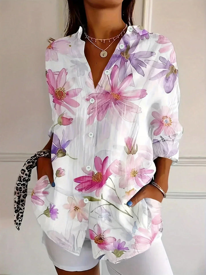 Playful patterned women’s blouse displayed w/ model on a clean background.