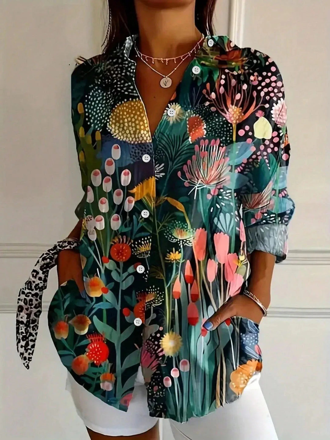 Lightweight colourful blouse with relaxed drape shown w/ model against a plain background.
