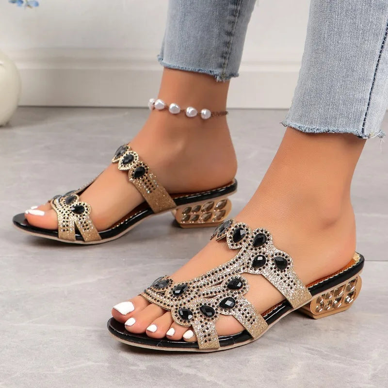 Female feet in chic embellished sandals on a plain background.
