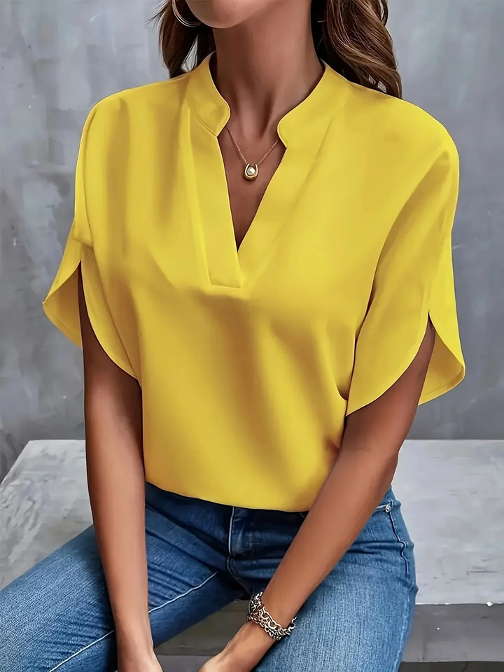 Structured blouse displayed with a model on a plain background showcasing a defined waistline.