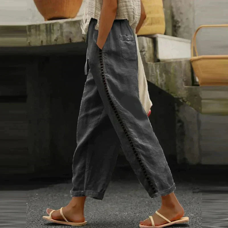 Model wearing breezy wide-leg trousers with side trim detail