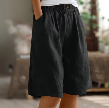 Female model in casual lightweight shorts for warm weather on a clean background.