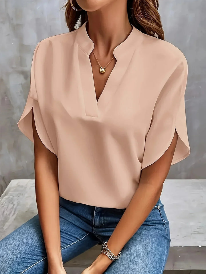 Minimalist blouse styled with a model on a clean background emphasizing shoulder definition.