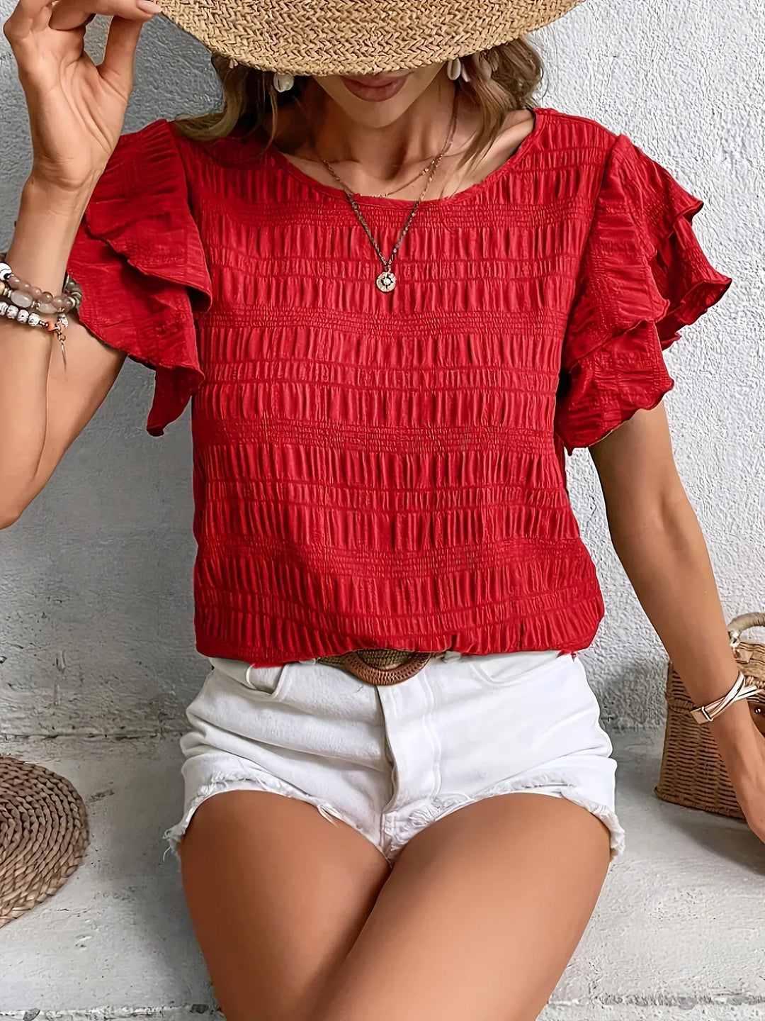 model wearing a breezy ruffle blouse against a plain background.