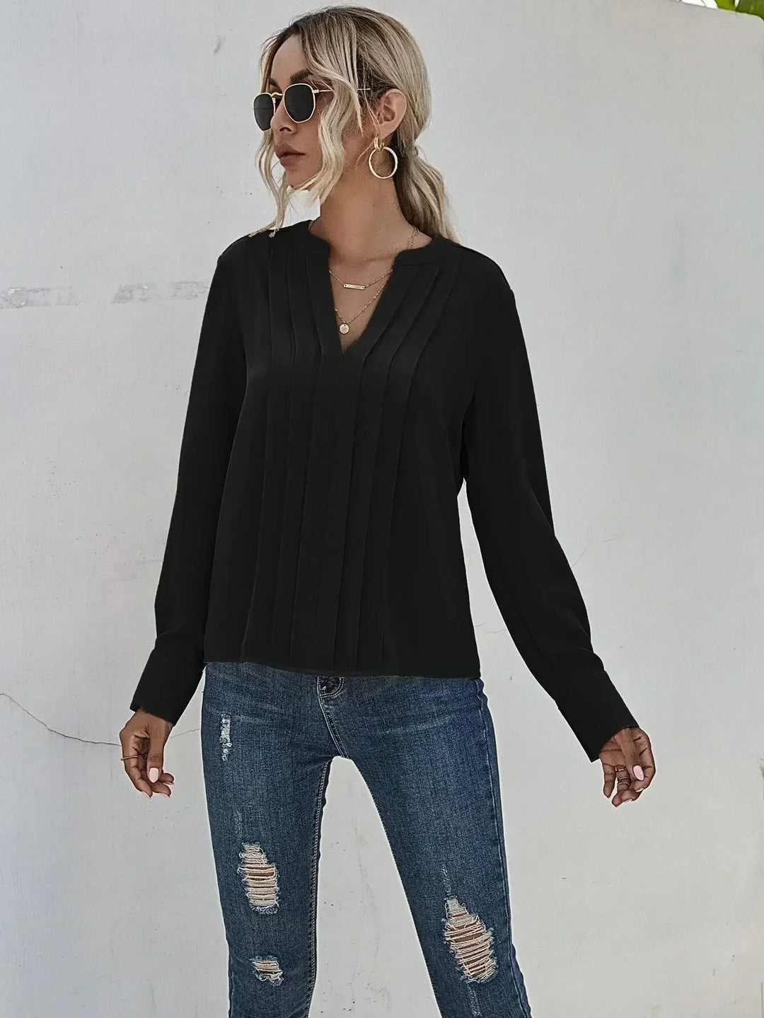 Soft pleated women’s blouse presented on a person with a clean background.