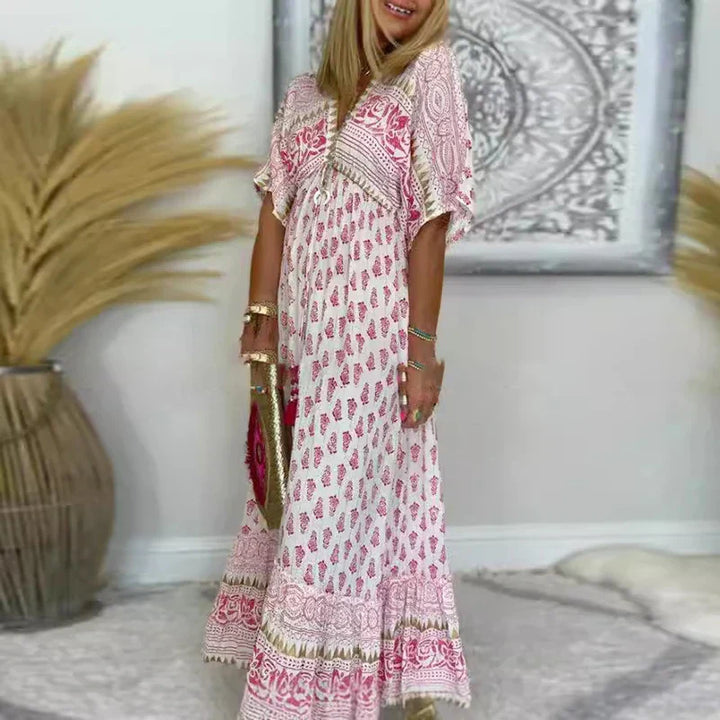 Female model wearing a flowing boho maxi dress against a plain background.
