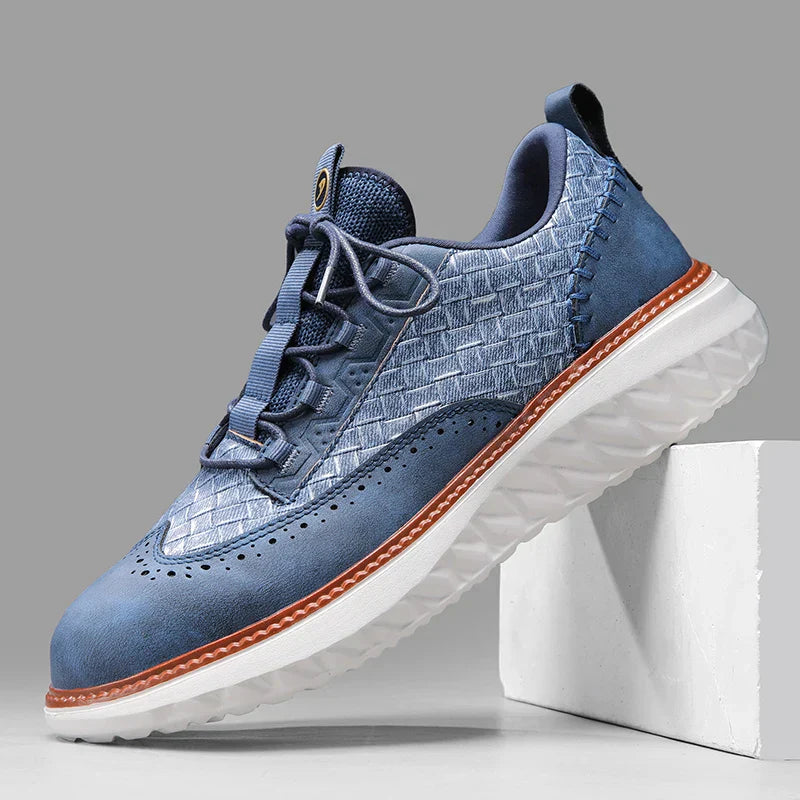 Men’s lightweight sneakers on feet against a plain background.
