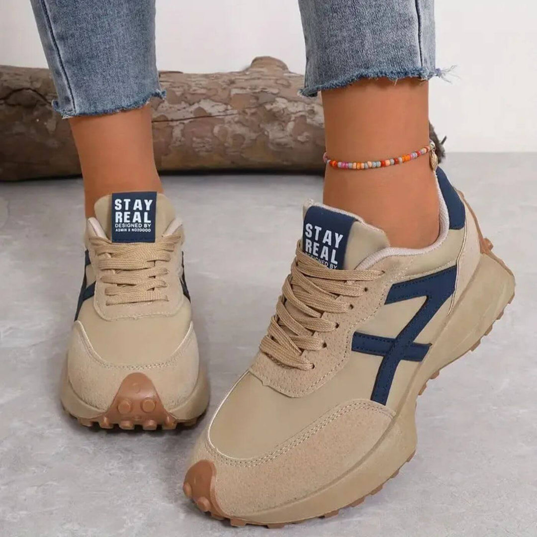Female model showcasing lightweight lace-up sneakers on a plain background.
