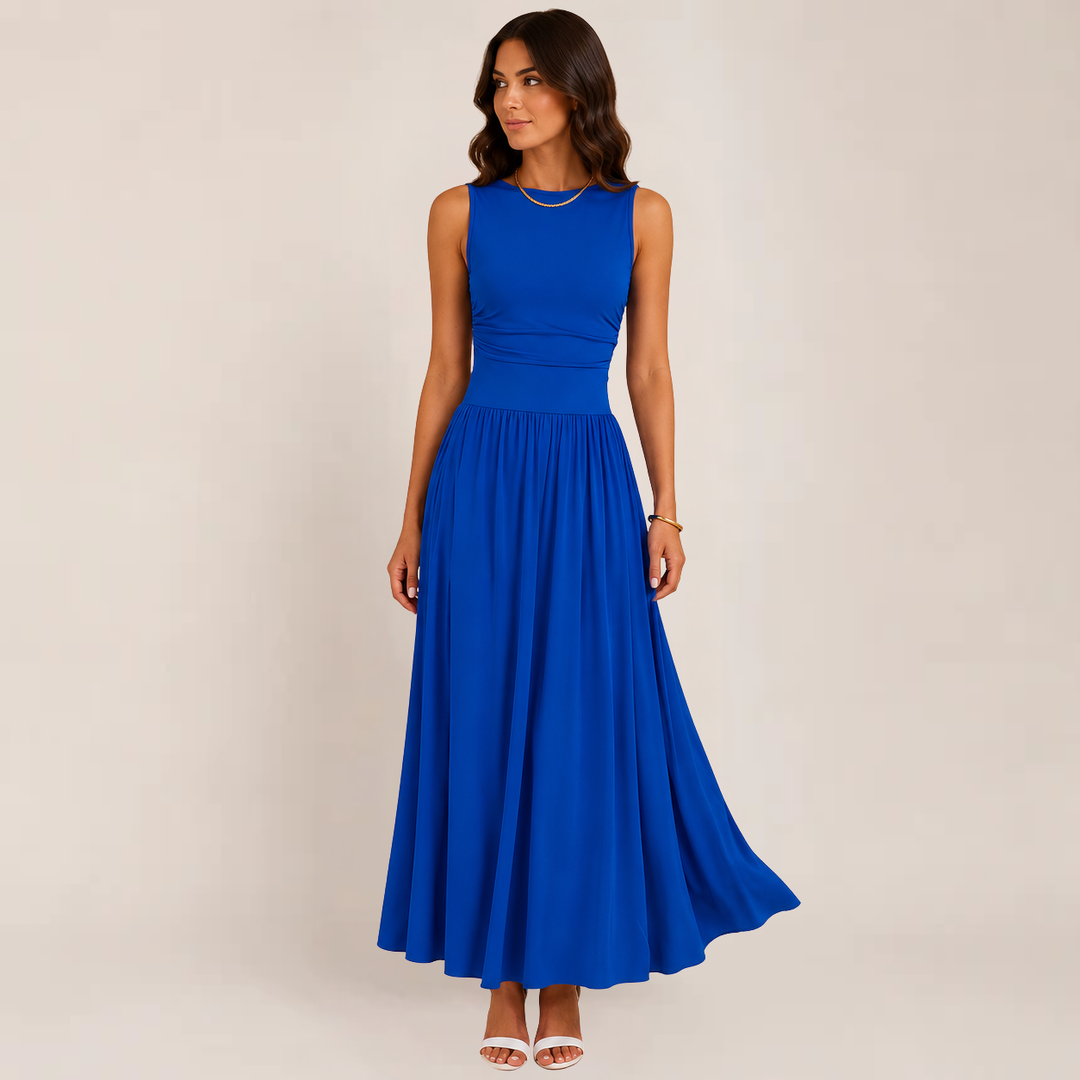 Female model showcasing an elegant ruched evening dress on a plain background.