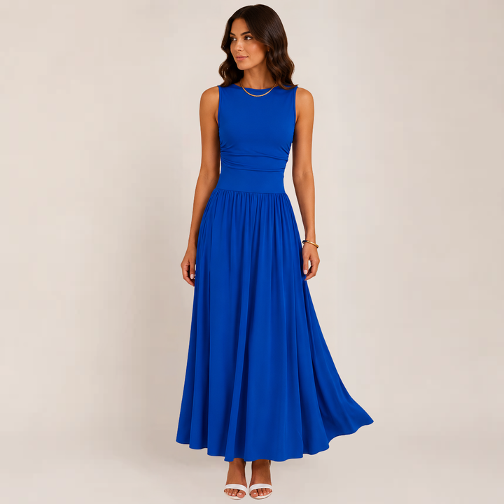 Female model showcasing an elegant ruched evening dress on a plain background.