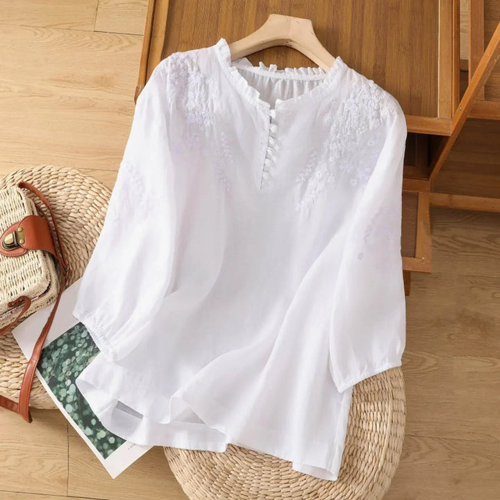 Women’s embroidered button-front blouse on a clean background.