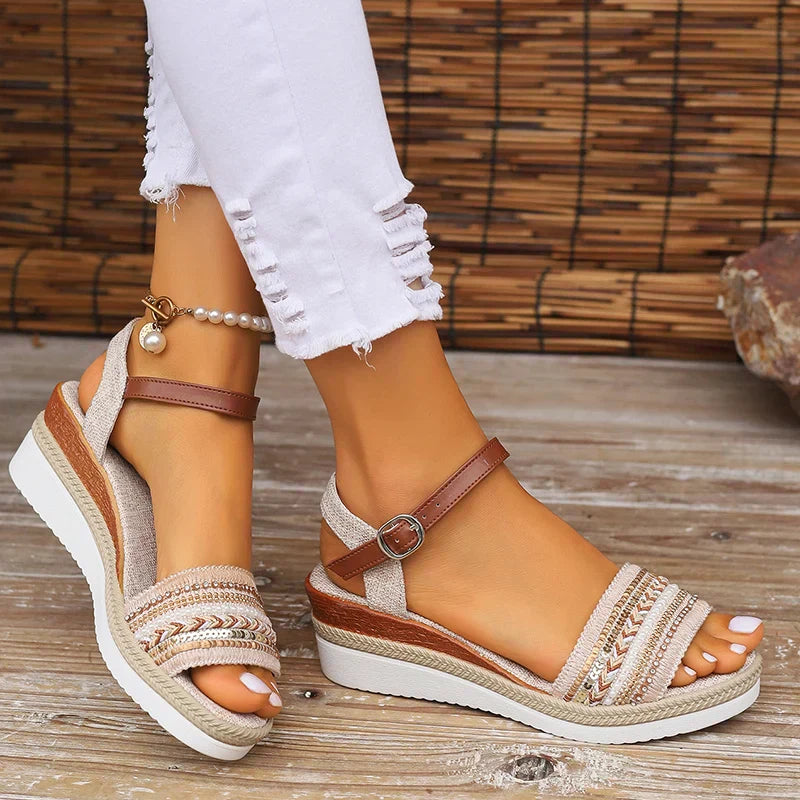 Woman feet in lightweight summer sandals with woven details on plain background