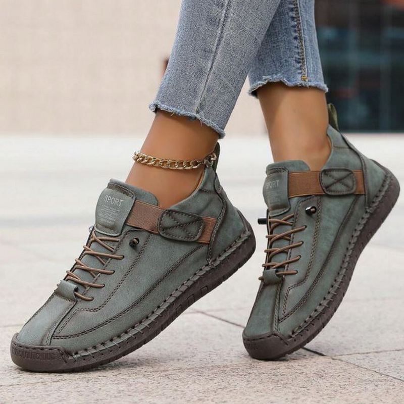 Female feet showcasing modern slip-on sneakers on a plain background.