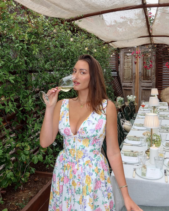 Model wearing a flattering warm-weather dress on a nature background.