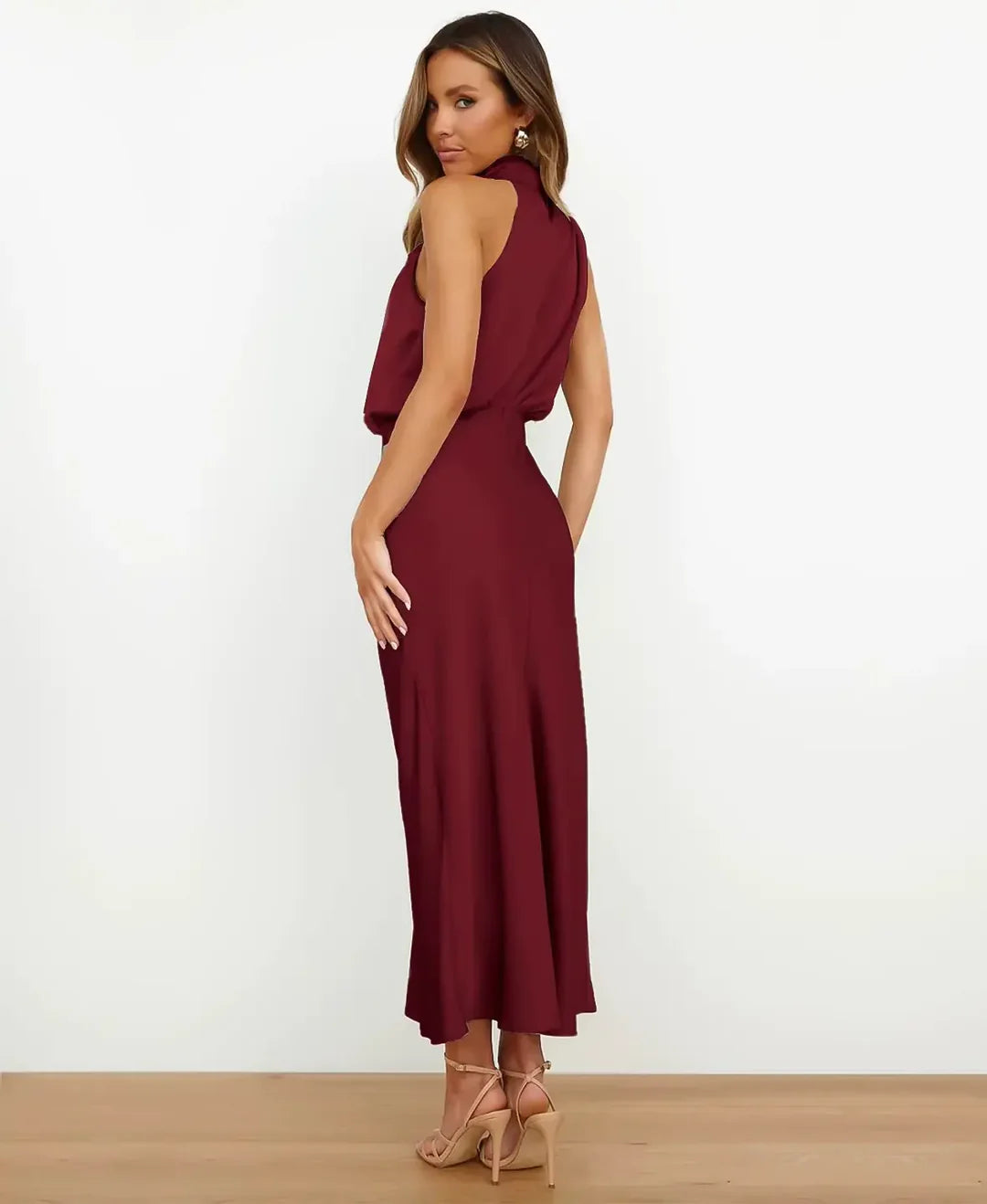 Woman showcasing a high waist midi dress on a plain studio background.