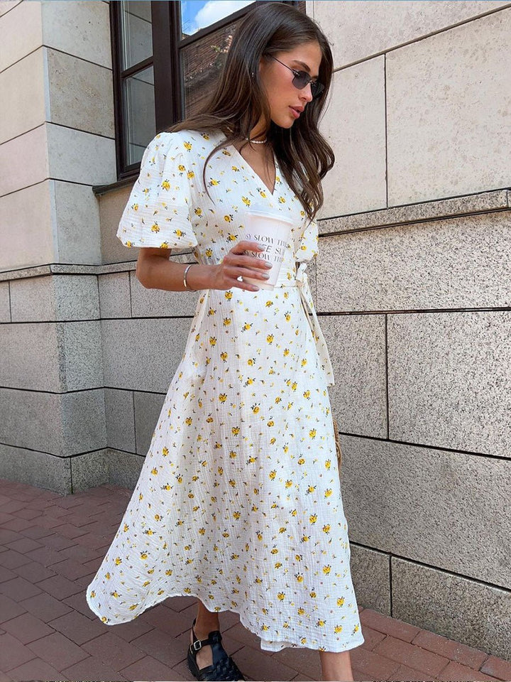  Female presenting a stylish floral dress with a side slit on a plain background.