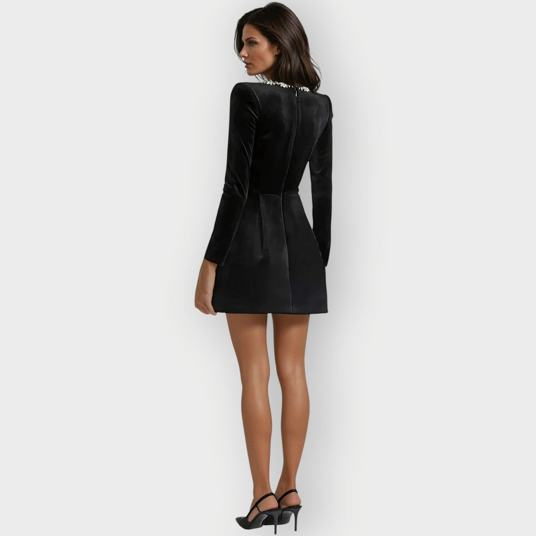 Woman wearing a stylish velvet dress designed with a modern square-neck cut.