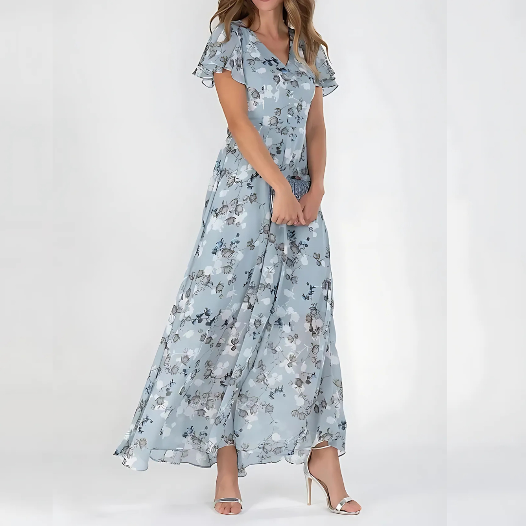 Female model in a floral dress with a relaxed silhouette on a plain background.
