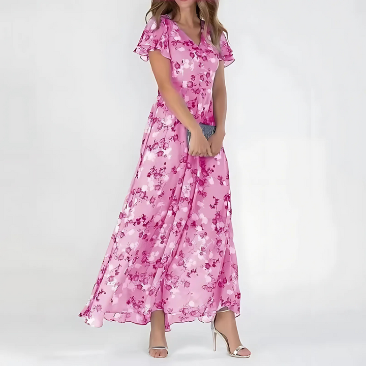 Woman showcasing a spring floral dress against a plain background.