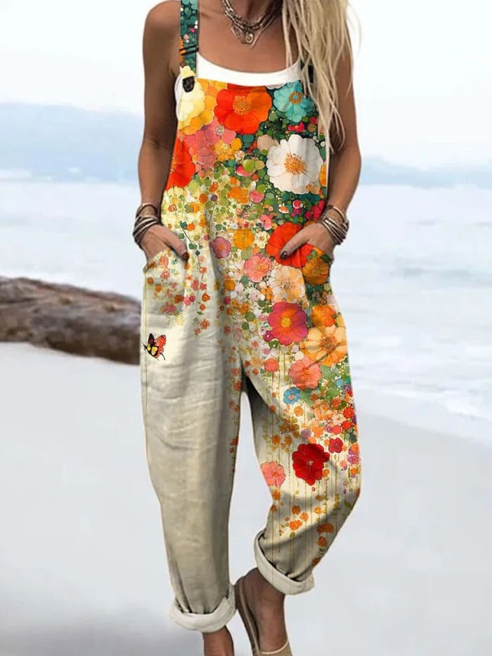 Woman posing in a playful floral-style jumpsuit on a plain backdrop.