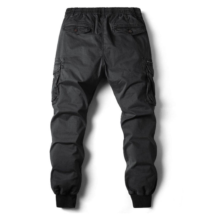 Male model wearing tapered cargo pants on a plain background.