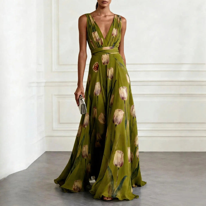 Female wearing an elegant sleeveless floral gown on a plain background