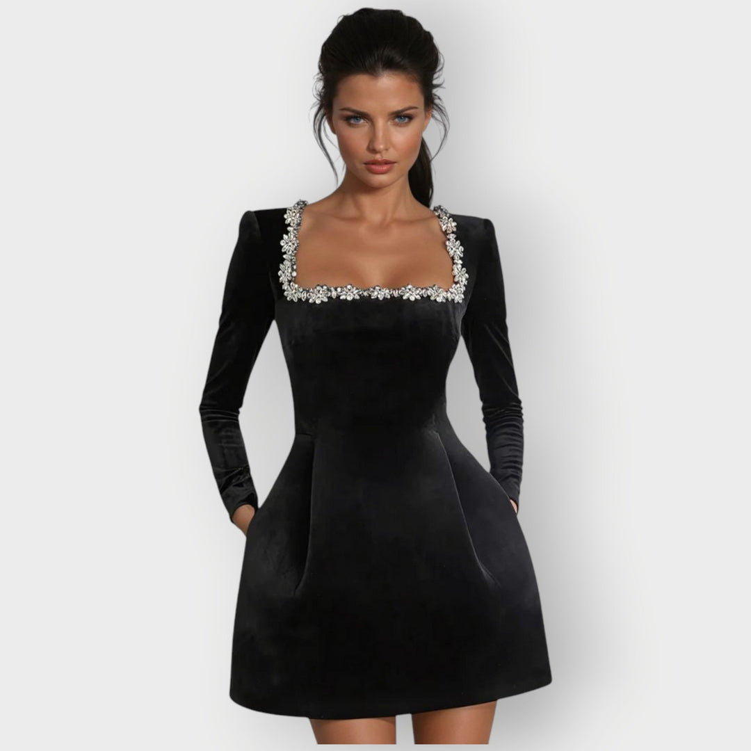 Female model wearing a velvet mini dress with a square neckline against a plain background.