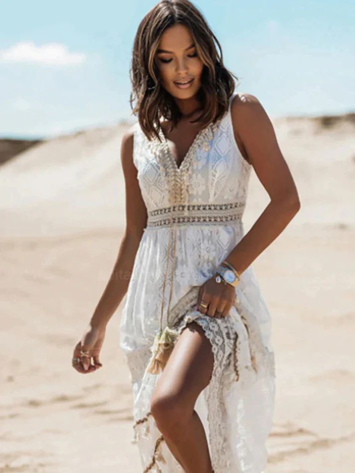 Woman posing in a relaxed boho-inspired long dress on a plain background.