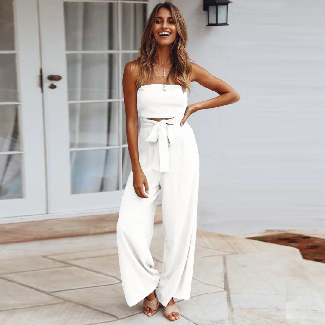 Female model in a strapless jumpsuit styled with a tied waist belt.