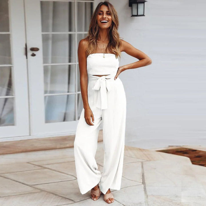 Female model in a strapless jumpsuit styled with a tied waist belt.