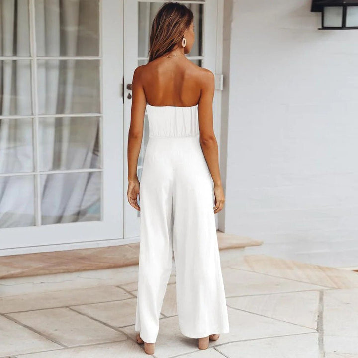 Woman modeling a bandeau neckline jumpsuit with flowing wide-leg pants.