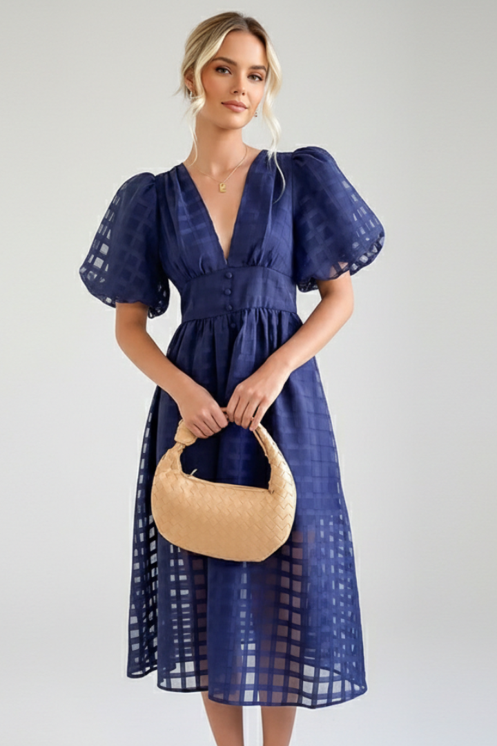 Midi dress with fitted waist on model holding a bag