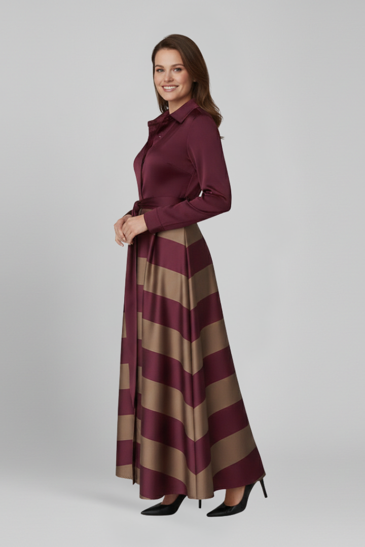 Female model in long striped dress, side angle, gray background.