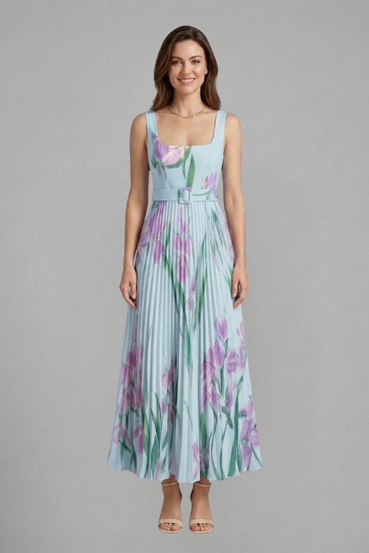 Model standing in elegant pleated dress gray background
