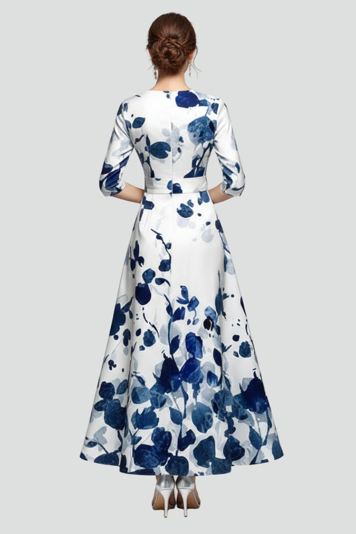 Woman posing back printed long dress plain gray backdrop