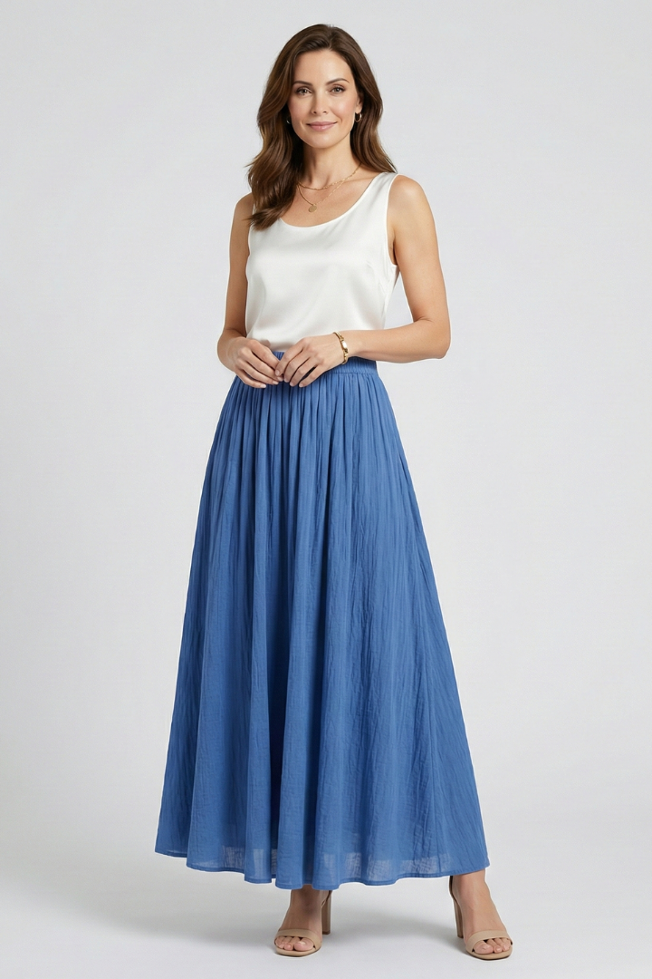Model wearing long flared blue skirt front view gray background