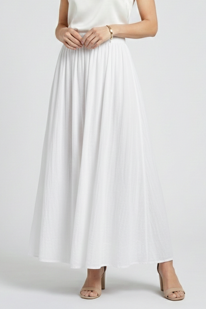 Model wearing floor-length white skirt straight front gray background