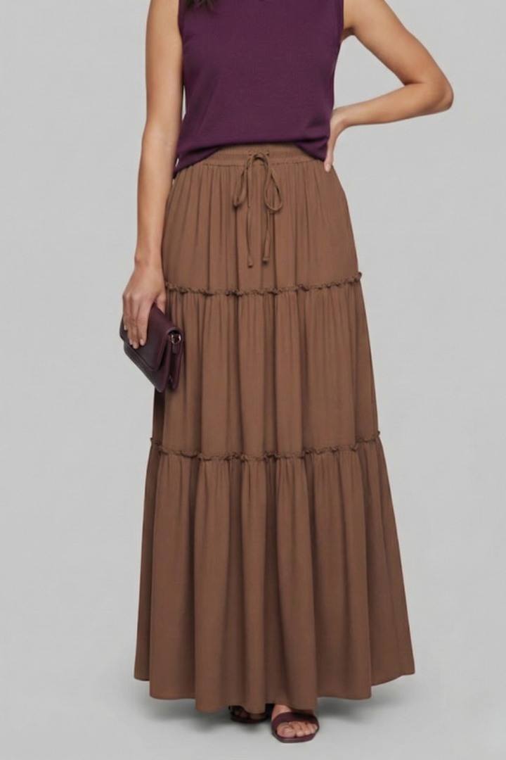 Model front pose maxi brown skirt in gray background 