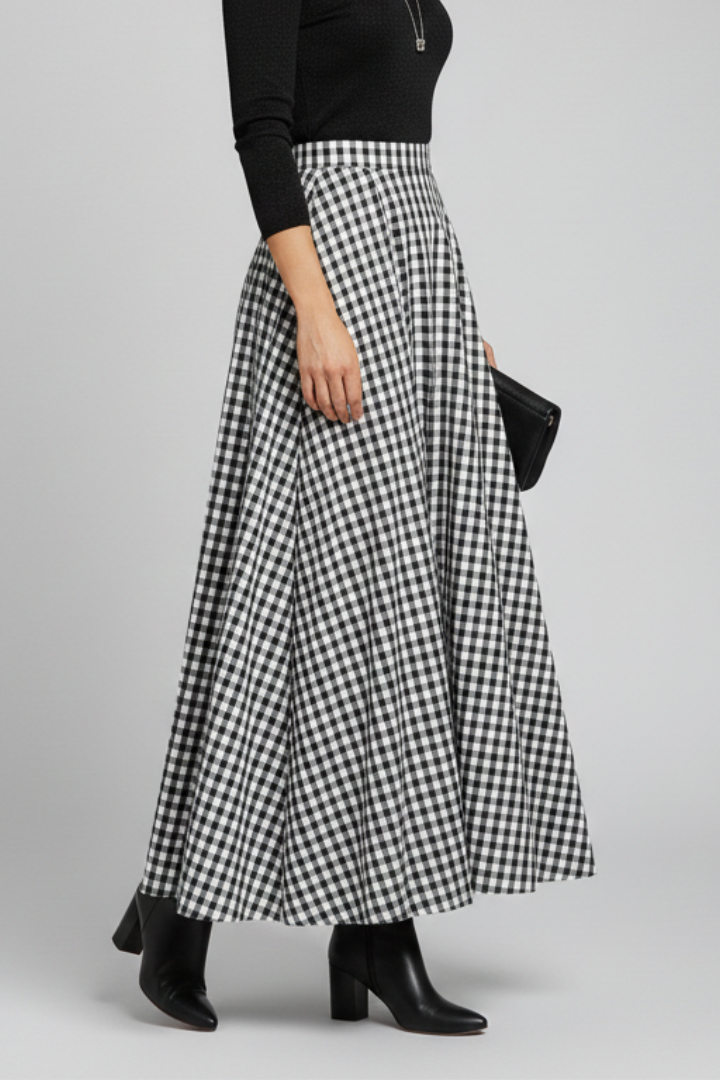 Model posing in asymmetric hem skirt gray background