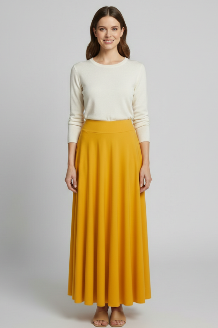 Model posing in elegant long yellow skirt gray background