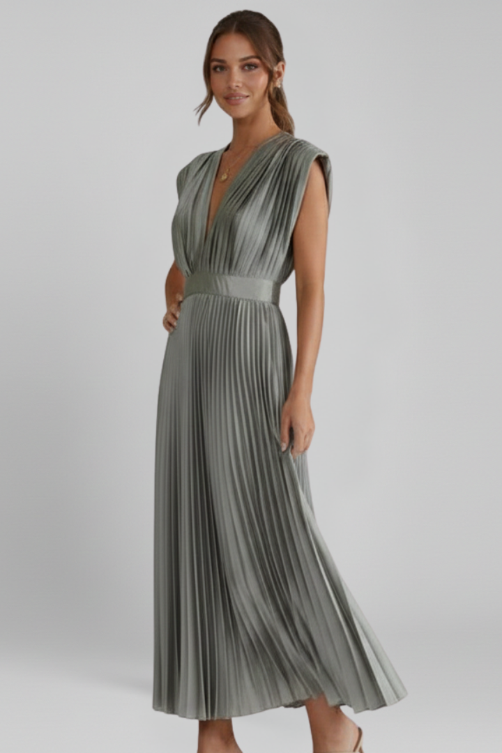 Model in side angle wearing pleated dress showing flowy silhouette